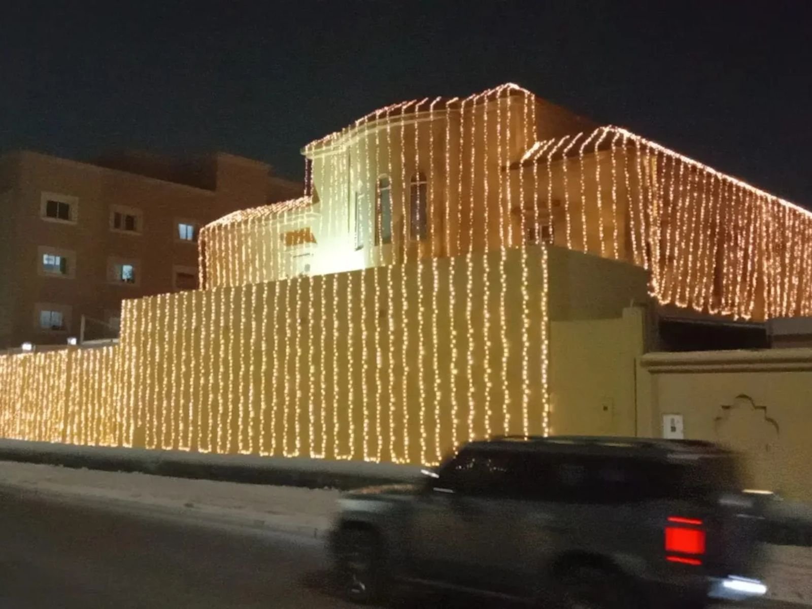 Home luxury wedding lighting decoration in qatar featuring a villa fully covered with warm white fairy lights for an elegant night wedding setup.