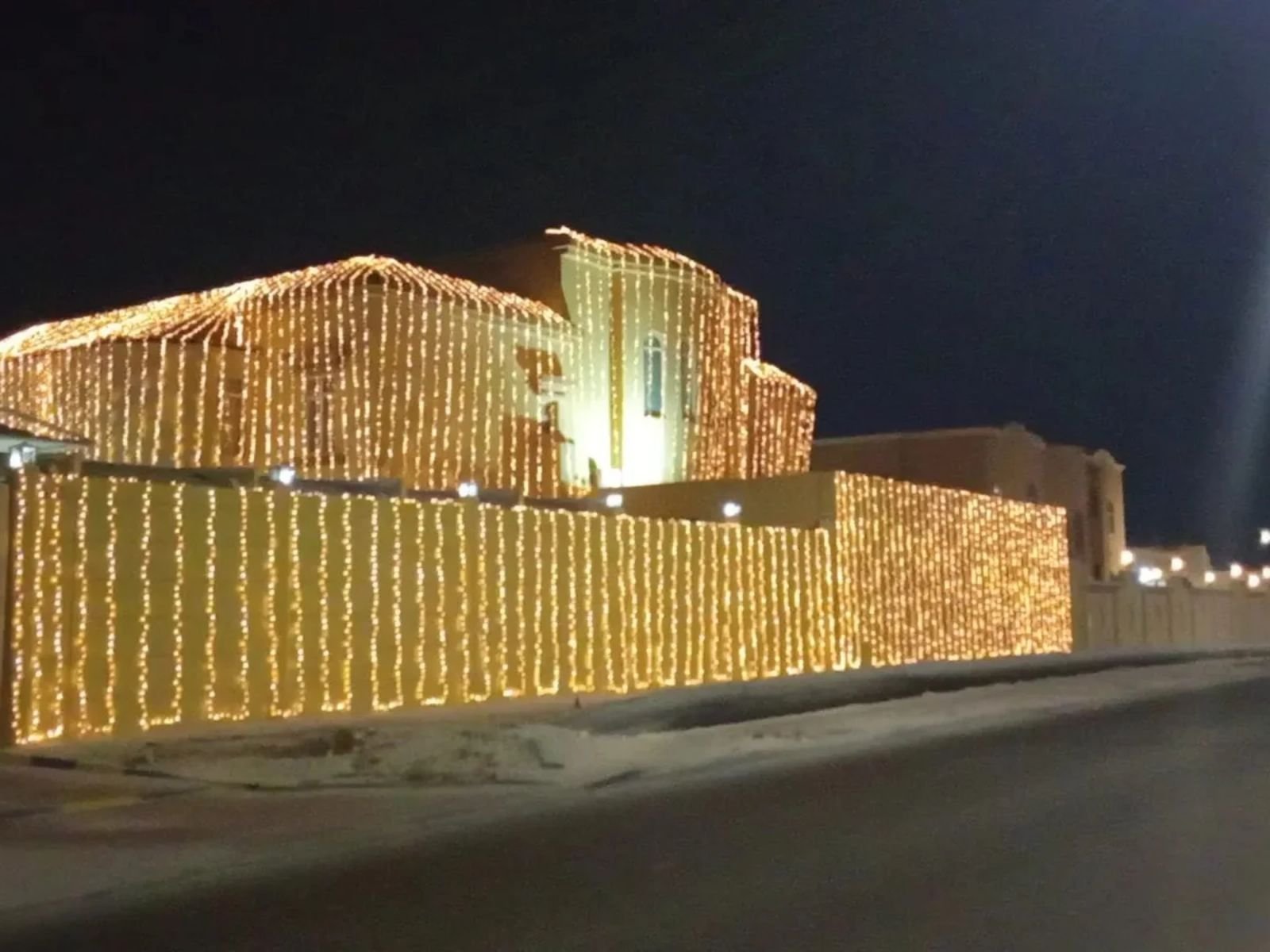 Home wedding villa lighting in qatar with warm white curtain led lights covering the exterior walls and boundary for an elegant night celebration
