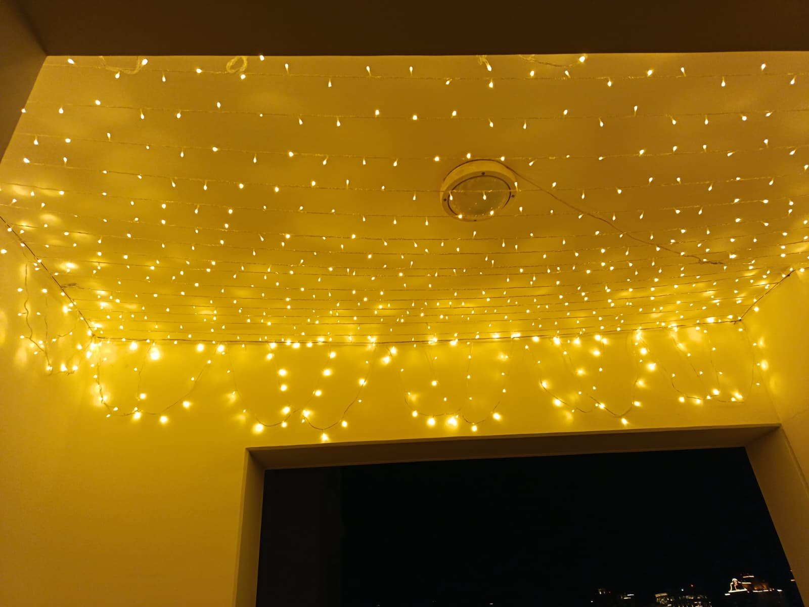 Home luxury wedding lighting design with cascading warm fairy lights across a ceiling, ideal for outdoor and balcony wedding venues in qatar.