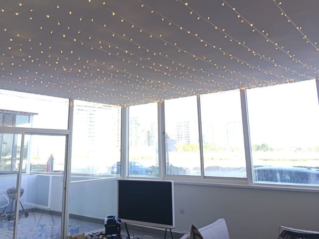 indoor ceiling fairy light installation in doha featuring warm led canopy lighting inside a glass enclosed event space.