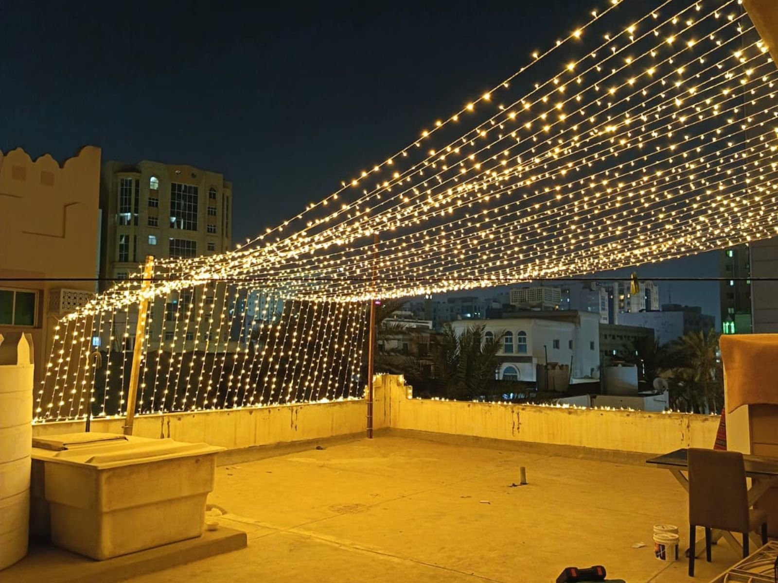 Home rooftop canopy wedding lighting installation in al muntazah doha featuring warm cascading fairy lights.
